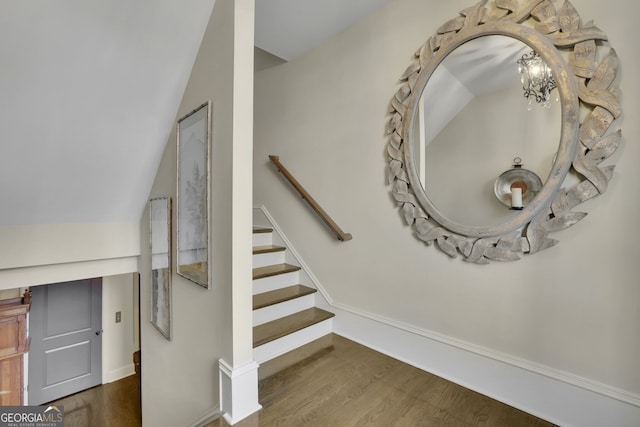 stairs with vaulted ceiling and wood finished floors