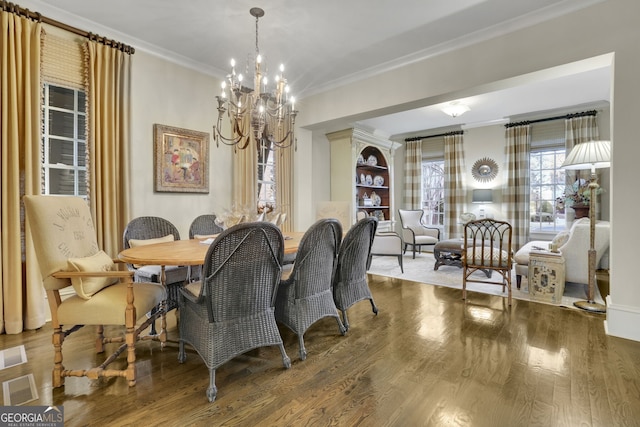 dining area featuring dark wood-style floors, a chandelier, visible vents, and crown molding