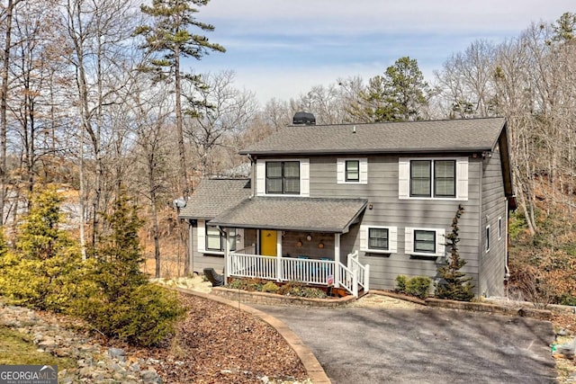 view of front of house with covered porch and a shingled roof