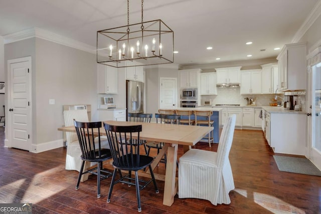 dining area featuring dark wood-style flooring, recessed lighting, ornamental molding, a chandelier, and baseboards