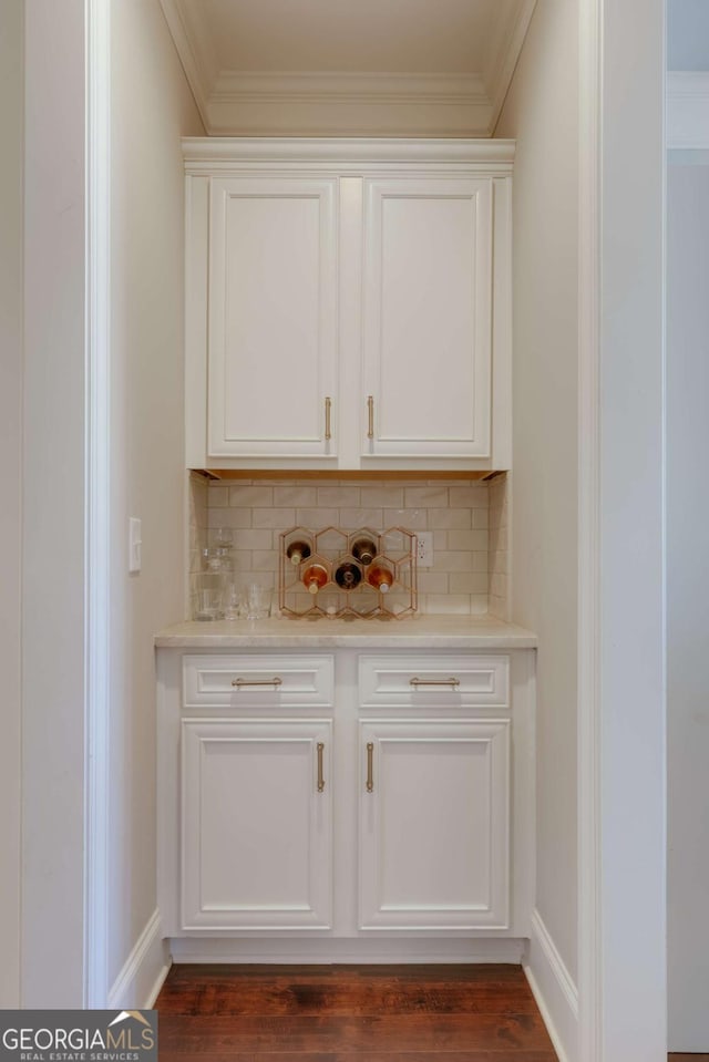 bar with ornamental molding, backsplash, and baseboards