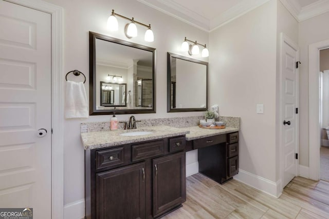 bathroom with baseboards, ornamental molding, wood finished floors, and vanity