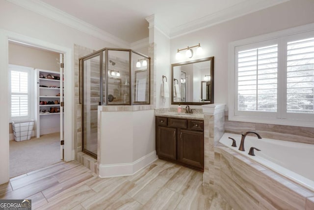 bathroom with a garden tub, a shower stall, crown molding, and vanity