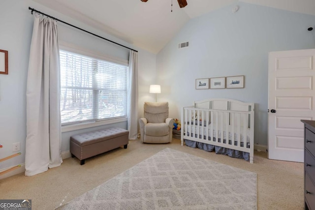 bedroom with lofted ceiling, visible vents, a ceiling fan, light carpet, and a crib