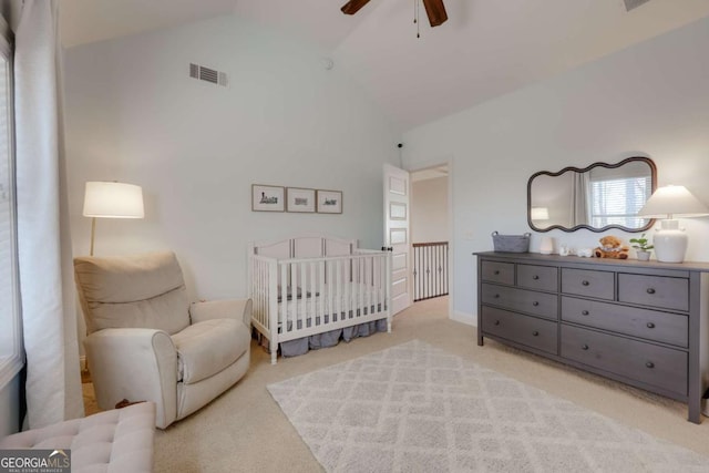 bedroom featuring light carpet, visible vents, ceiling fan, vaulted ceiling, and a nursery area