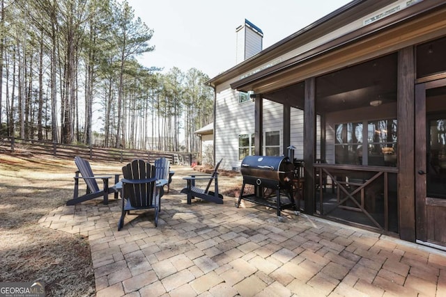 view of patio / terrace with a sunroom and a grill