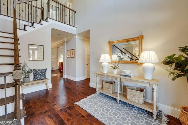 foyer entrance featuring stairs, a high ceiling, wood finished floors, and baseboards