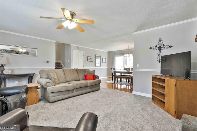 living area with ornamental molding, ceiling fan, a textured ceiling, baseboards, and stairs