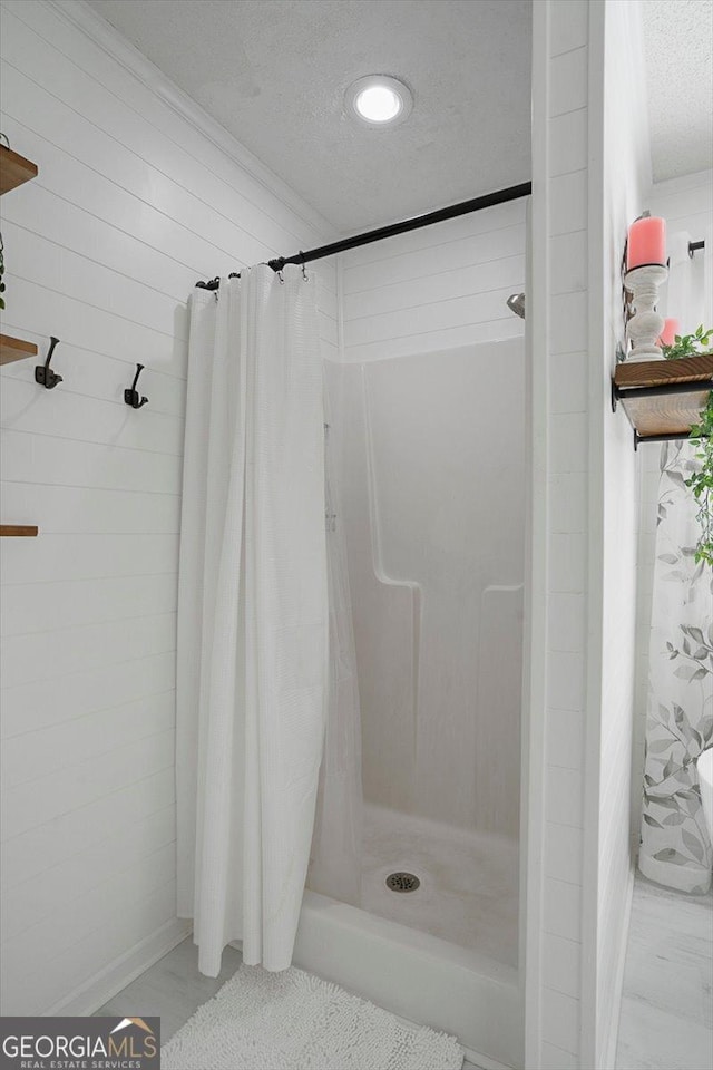 bathroom with a stall shower and a textured ceiling