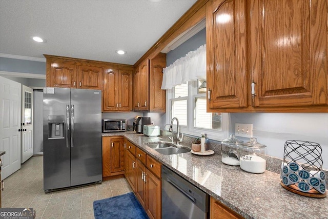 kitchen featuring ornamental molding, brown cabinetry, a sink, and stainless steel appliances