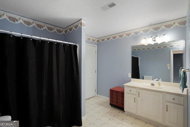 bathroom with tile patterned floors, curtained shower, vanity, visible vents, and a textured ceiling