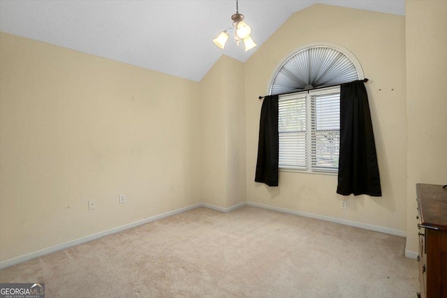 carpeted spare room featuring baseboards and lofted ceiling