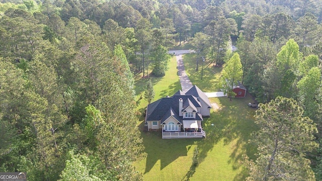 bird's eye view with a wooded view