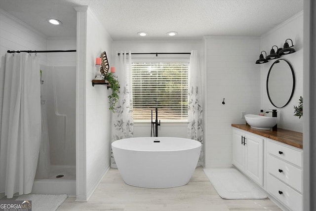 full bath featuring a textured ceiling, curtained shower, vanity, and a freestanding bath