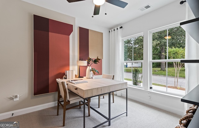 office area with baseboards, a ceiling fan, and light carpet