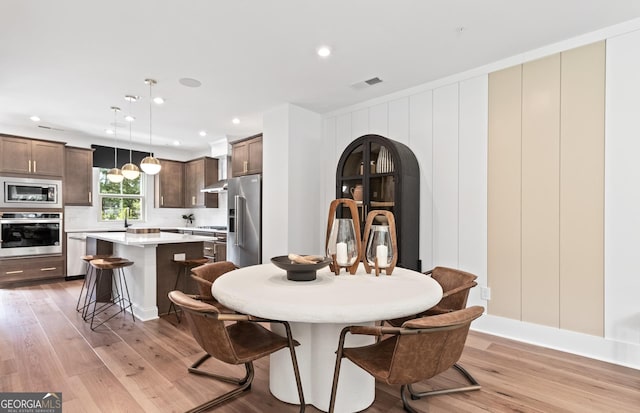 dining room with light wood finished floors and recessed lighting