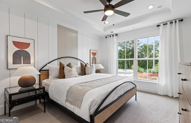 bedroom featuring a tray ceiling, light colored carpet, and recessed lighting