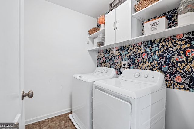 laundry area with washing machine and dryer, cabinet space, and baseboards