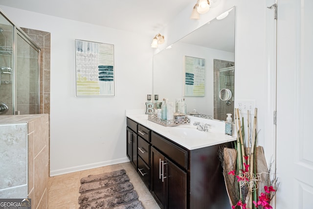 bathroom featuring double vanity, a stall shower, a sink, tile patterned flooring, and baseboards