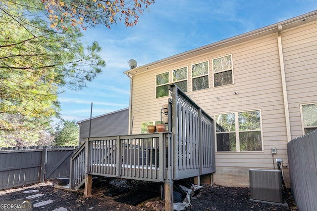 back of property featuring fence, a deck, and cooling unit