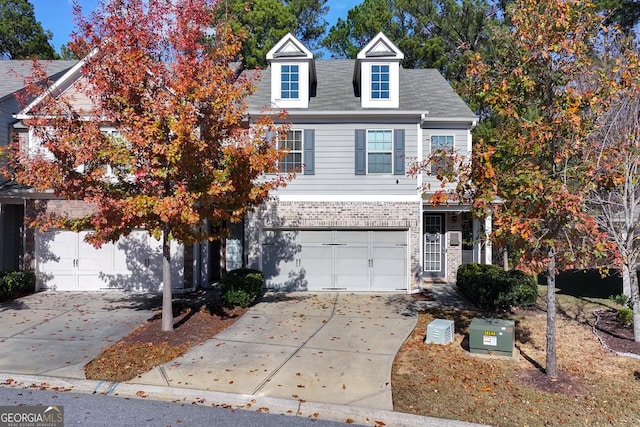 view of front facade featuring a garage, driveway, and brick siding