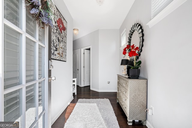 hall with dark wood-type flooring and baseboards