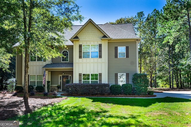 view of front of home featuring board and batten siding, stone siding, roof with shingles, and a front lawn