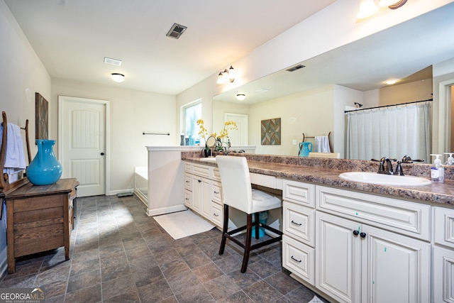 full bathroom featuring double vanity, a garden tub, visible vents, and a sink