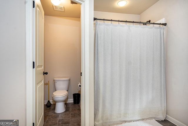 bathroom featuring toilet, tile patterned floors, visible vents, and baseboards