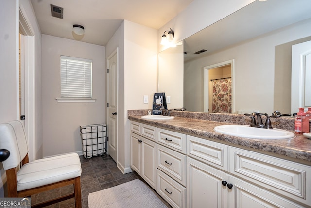 full bath with visible vents, a sink, and double vanity