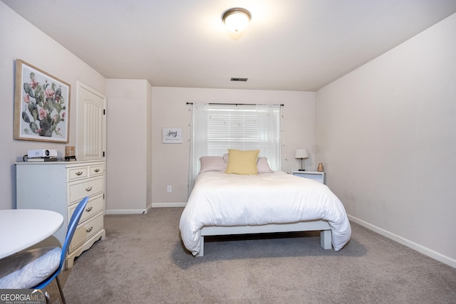 bedroom with light carpet, visible vents, and baseboards