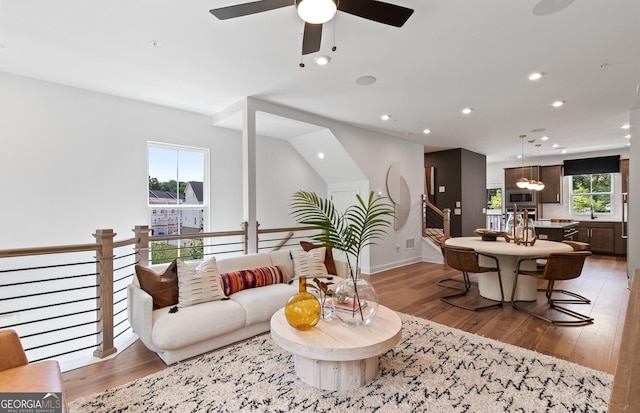 living area featuring light wood-type flooring, ceiling fan, baseboards, and recessed lighting