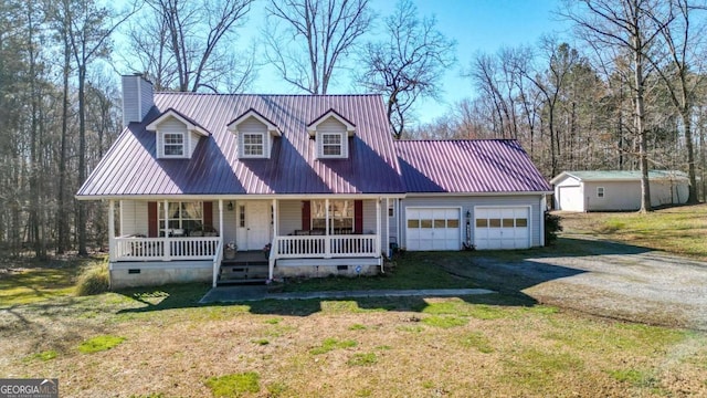 cape cod home with an outbuilding, metal roof, covered porch, driveway, and crawl space