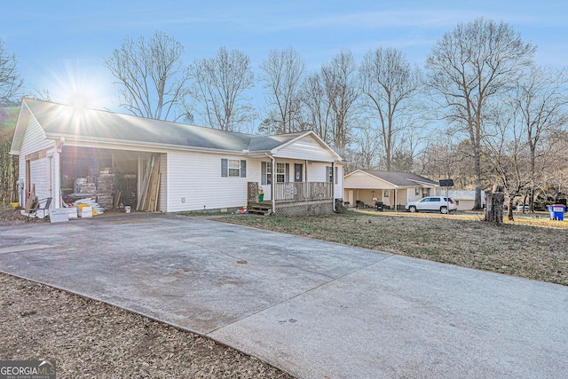view of front of home featuring an attached garage, covered porch, and concrete driveway