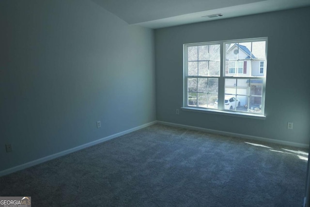 empty room featuring carpet, visible vents, and baseboards