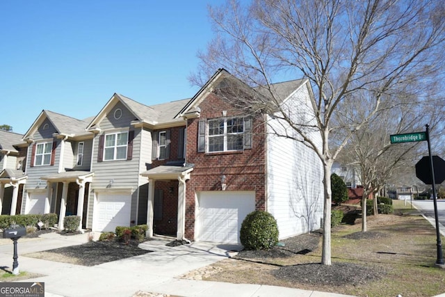 view of front of home with an attached garage, concrete driveway, and brick siding