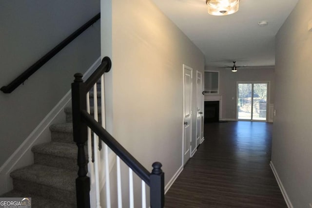 corridor featuring dark wood-style floors and baseboards