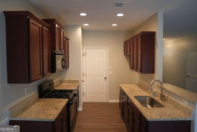 kitchen featuring visible vents, dark wood-style flooring, black appliances, a sink, and recessed lighting