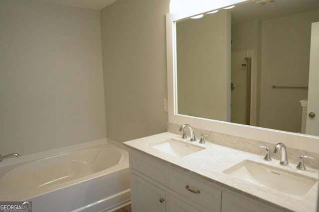 full bath featuring a bath, double vanity, and a sink