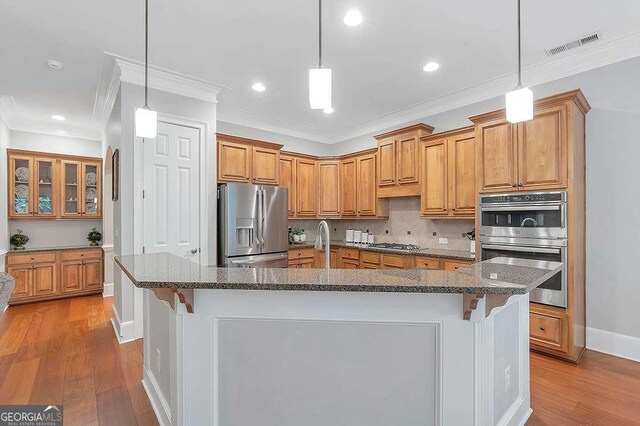 7524 Portbury Park Ln, Suwanee, GA 30024 - kitchen featuring stainless steel appliances, a kitchen bar, and a center island with sink