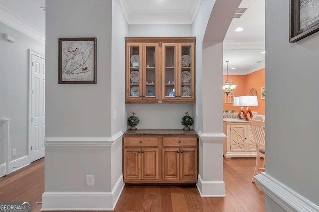 7524 Portbury Park Ln, Suwanee, GA 30024 - bar featuring light wood-style flooring, visible vents, baseboards, ornamental molding, and an inviting chandelier