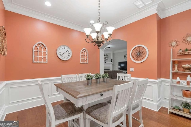 7524 Portbury Park Ln, Suwanee, GA 30024 - dining room with light wood-style flooring, a fireplace, visible vents, and crown molding
