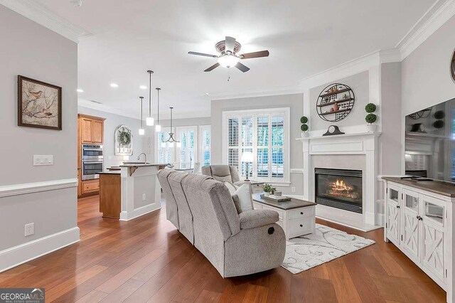 7524 Portbury Park Ln, Suwanee, GA 30024 - living room featuring ornamental molding, dark wood-style flooring, and a glass covered fireplace