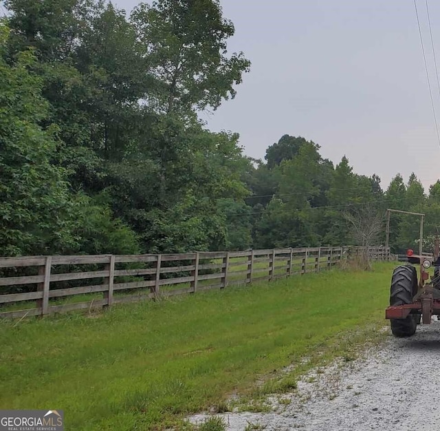 view of yard with a rural view and fence