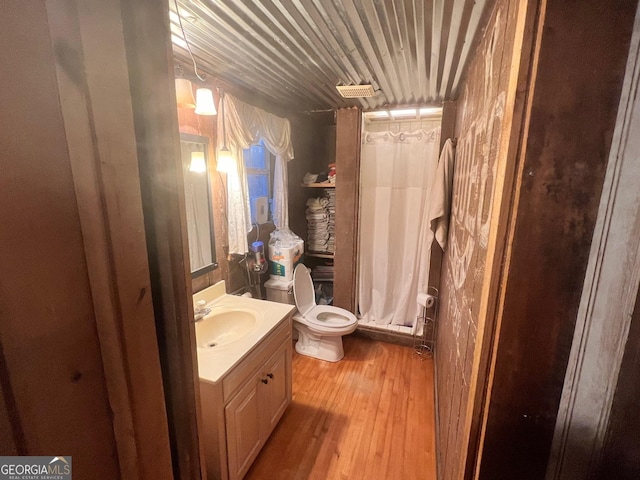 full bathroom with wooden ceiling, toilet, wood finished floors, vanity, and a stall shower