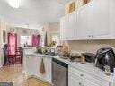 kitchen with stainless steel dishwasher, white cabinets, and light countertops