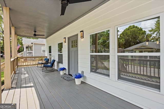 wooden deck with covered porch and a ceiling fan