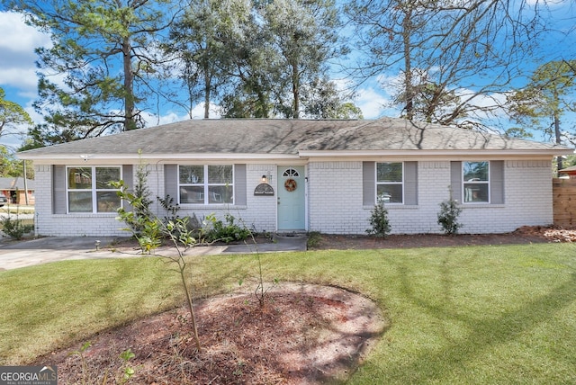 ranch-style house with a shingled roof, a front lawn, and brick siding