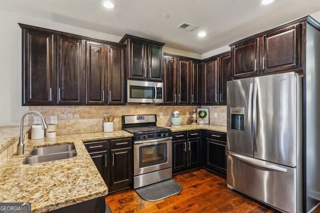 7420 Glisten Ave, Sandy Springs, GA 30328 - kitchen with appliances with stainless steel finishes, light stone countertops, dark wood-type flooring, backsplash, and dark brown cabinets
