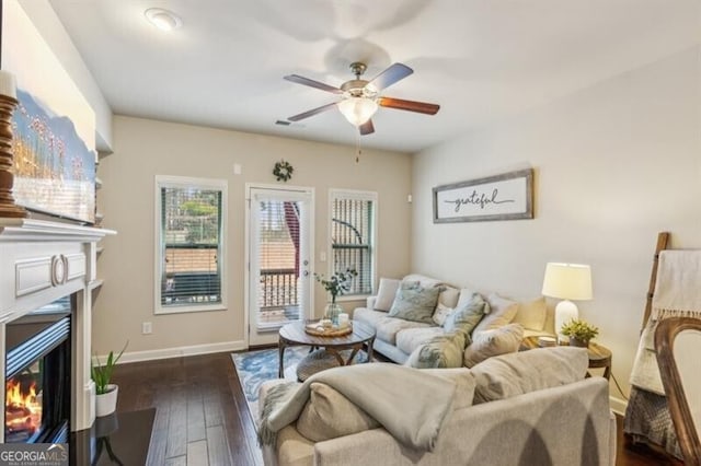 7420 Glisten Ave, Sandy Springs, GA 30328 - living area featuring a glass covered fireplace, a ceiling fan, and dark wood-style flooring